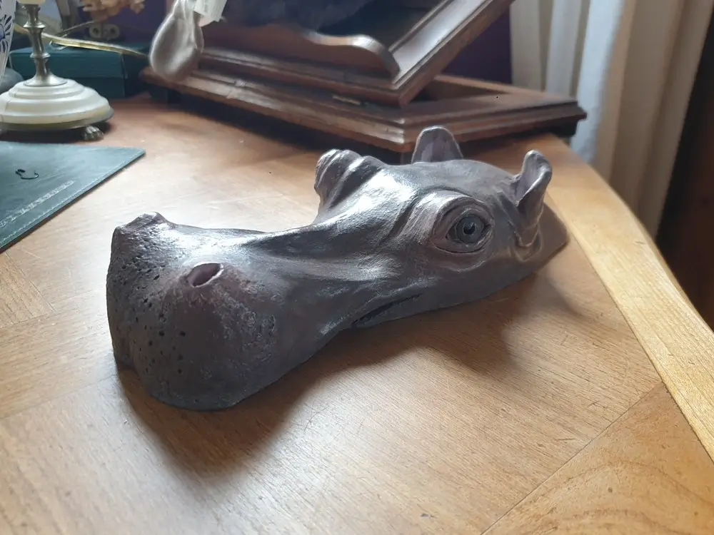 Sculpture argile hippopotame tête affleurant hors de l'eau, de trois quart
