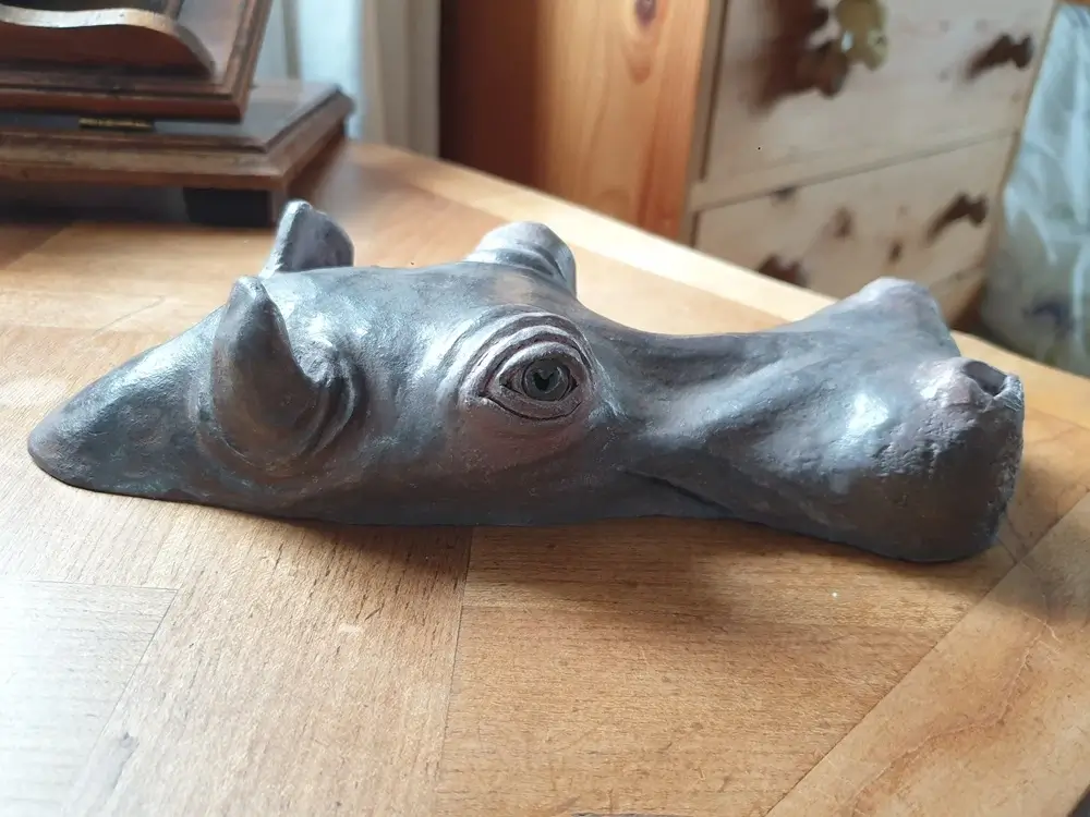 Sculpture argile hippopotame tête affleurant hors de l'eau, de profil