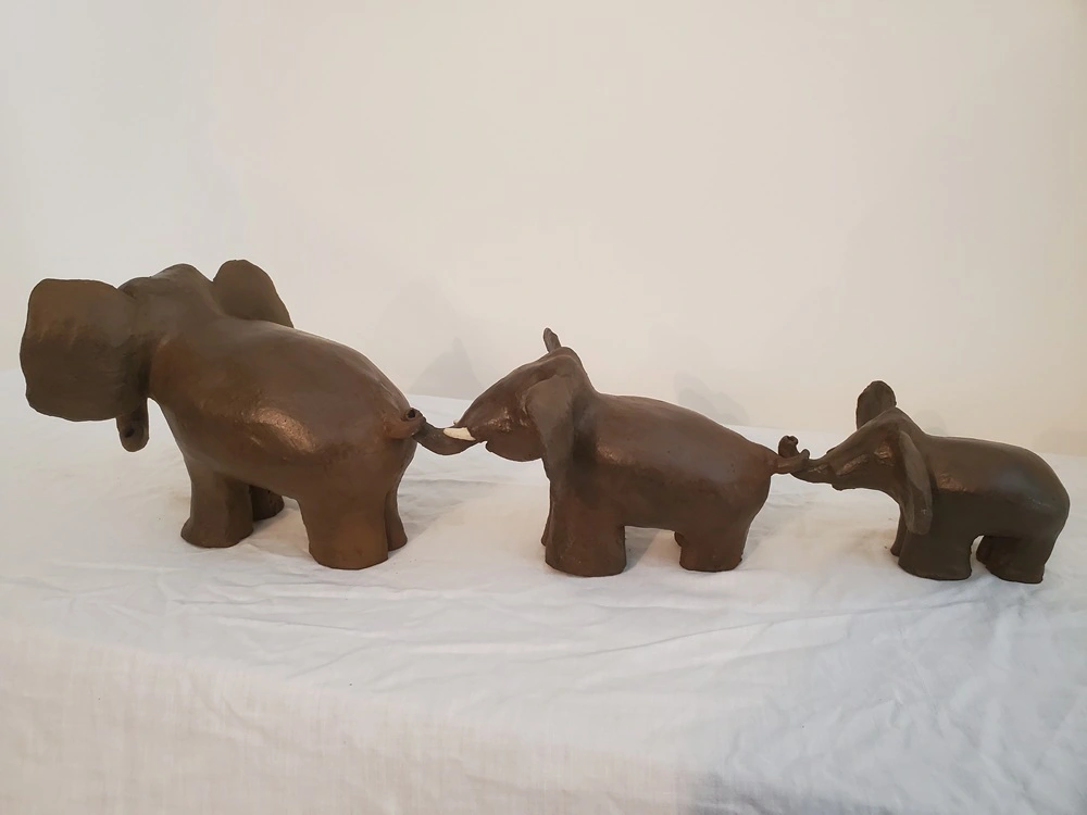 Sculpture trois éléphants à la queue leu leu vers la gauche